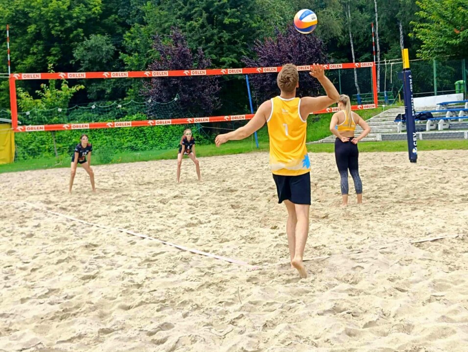 Zagrywka zawodnika podczas meczu siatkówki plażowej mixtów
