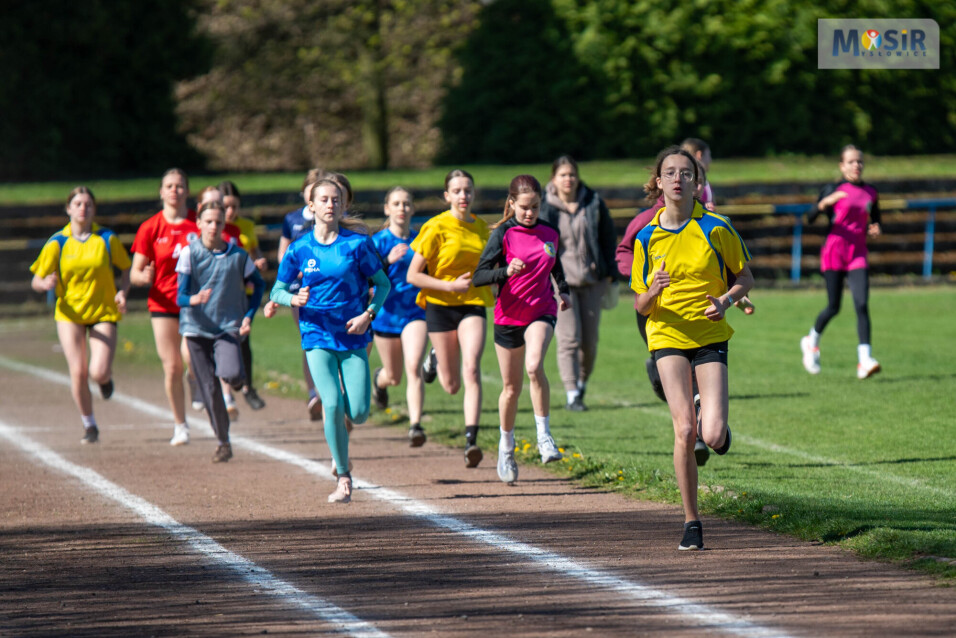Dziewczęta biegnące po bieżni podczas zawodów sportowych.