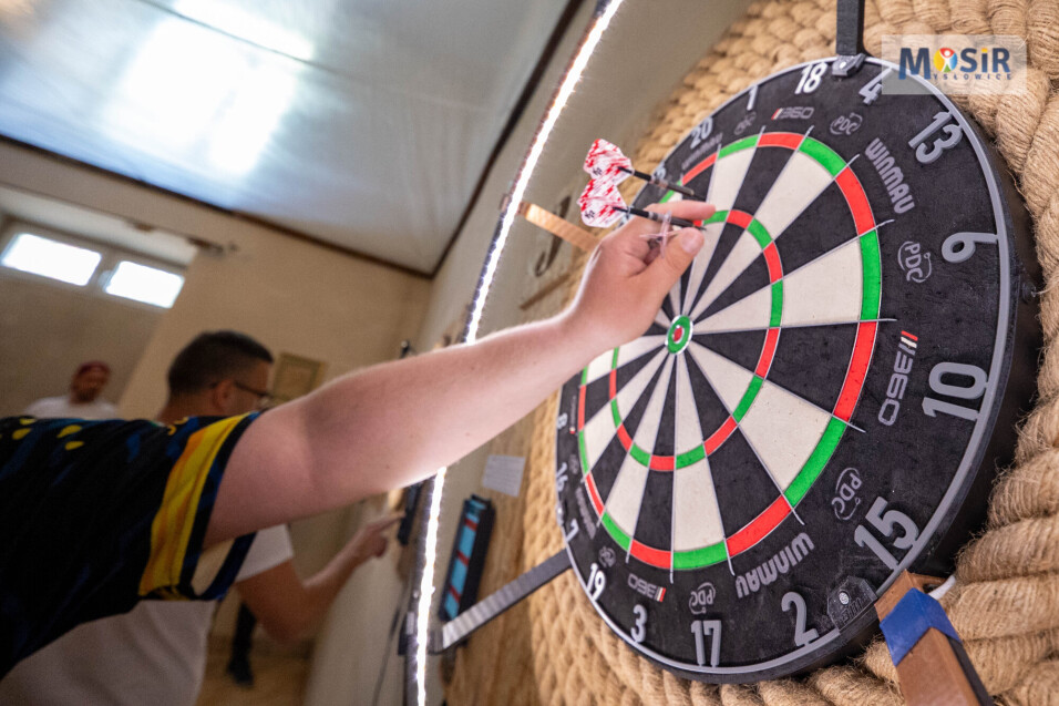 Dłoń wyciągająca rzutki z&nbsp;tarczy do&nbsp;darta. W górnym rogu logo MOSiR Mysłowice.